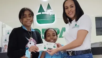 niñas recibiendo su libreta de ahorros en cooppais